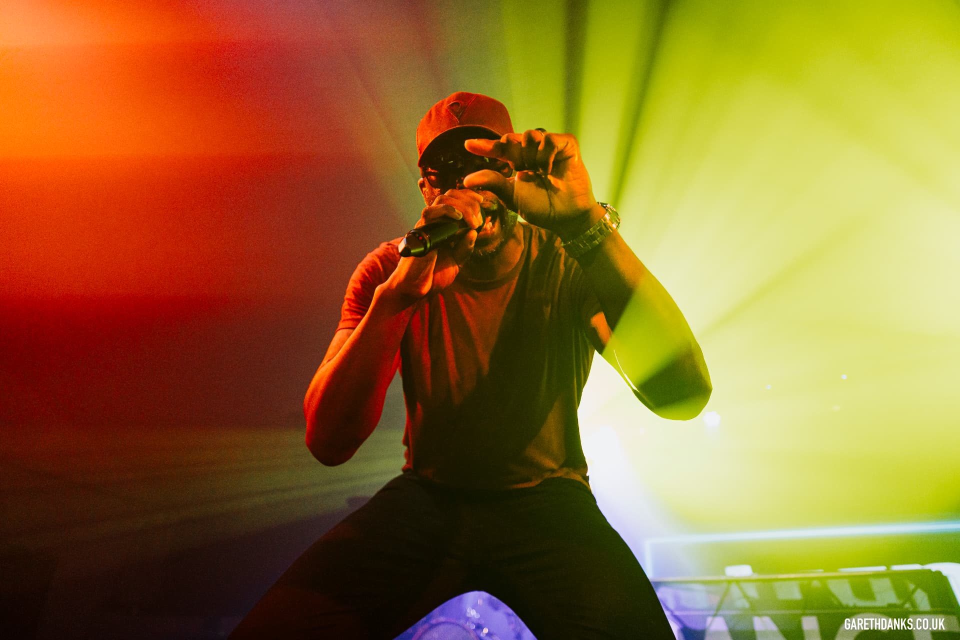 Jay Kurdy performing under red and green stage lights